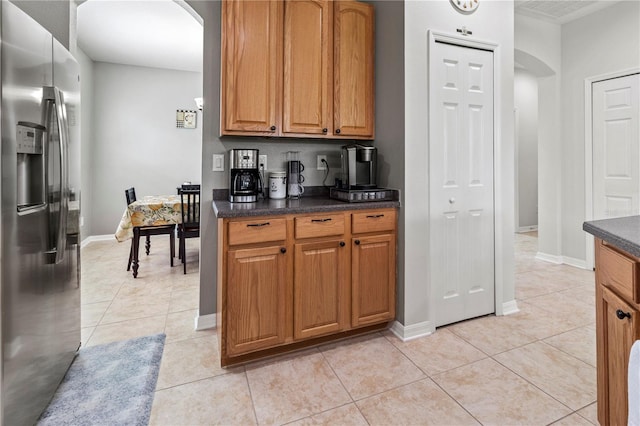 kitchen with light tile patterned floors and stainless steel fridge with ice dispenser