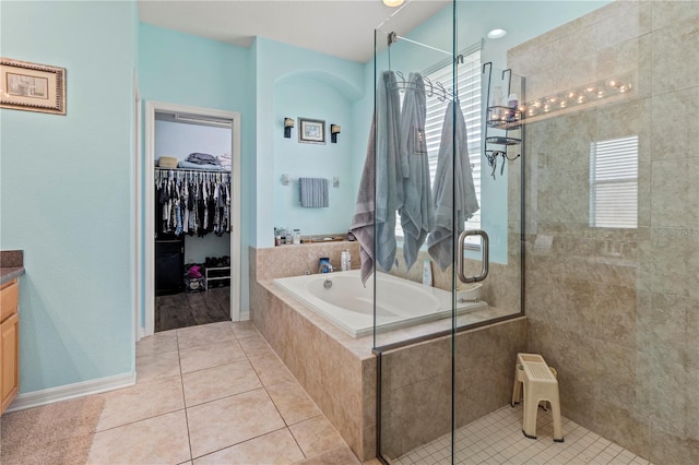 bathroom with tile patterned flooring, vanity, and plus walk in shower