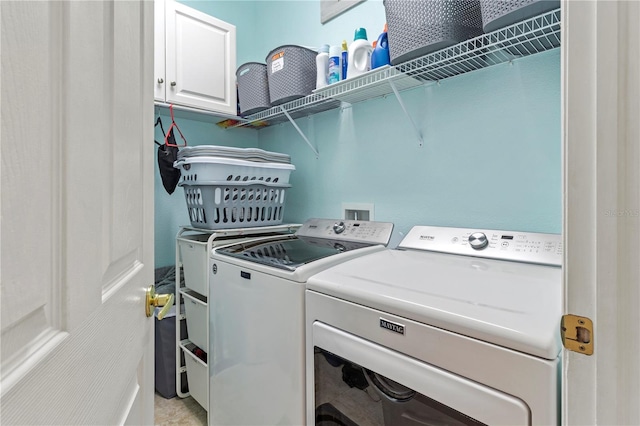 laundry area with separate washer and dryer and cabinets