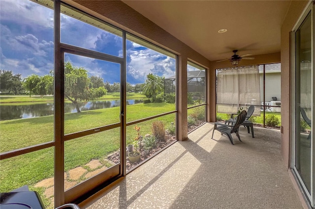 sunroom with a water view and ceiling fan