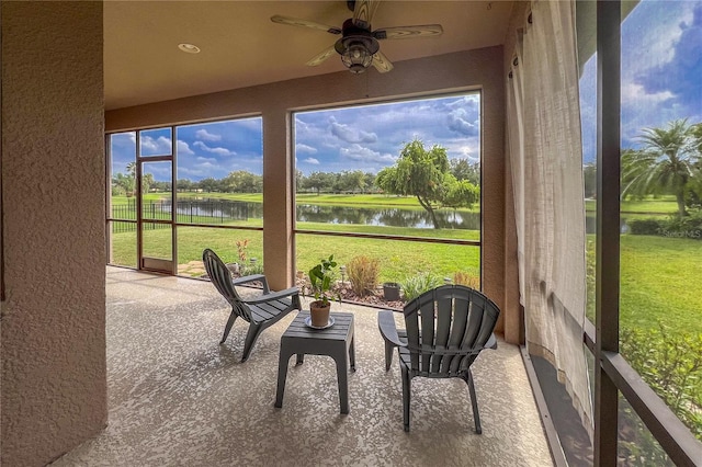 sunroom with a water view and ceiling fan