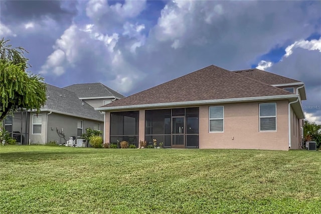 rear view of house with a lawn, cooling unit, and a sunroom