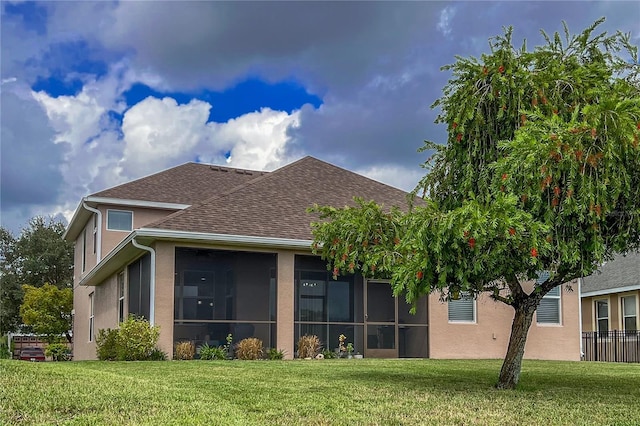 back of property with a sunroom and a yard