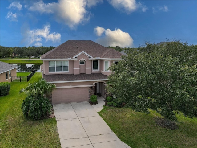 view of front facade featuring a water view, a garage, and a front lawn