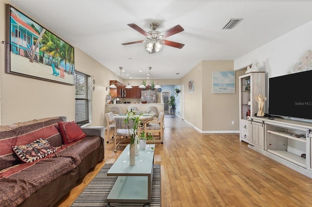 living room featuring light wood-type flooring and ceiling fan