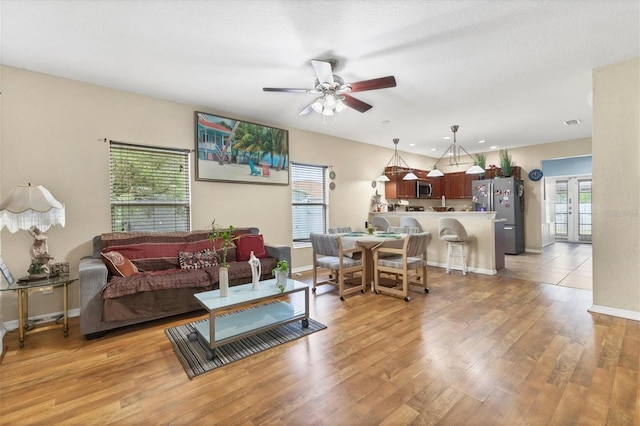 living room featuring ceiling fan and light wood-type flooring