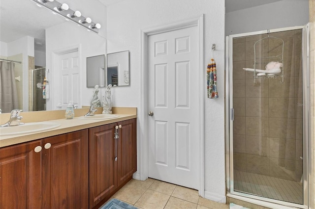 bathroom featuring tile patterned flooring, a shower with shower door, and vanity