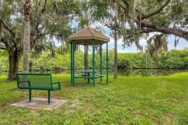 view of property's community with a lawn and a water view