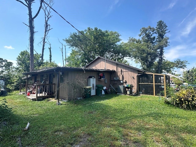 back of house with a sunroom and a yard