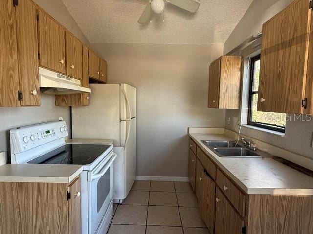 kitchen featuring under cabinet range hood, electric range, vaulted ceiling, and brown cabinetry