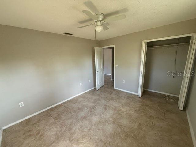 unfurnished bedroom with a ceiling fan, a closet, visible vents, and baseboards