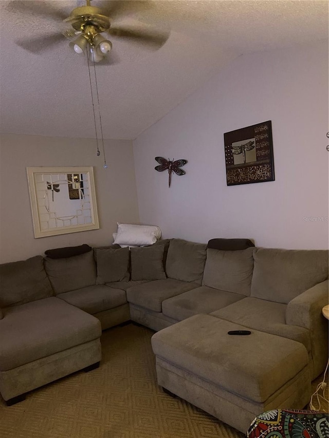 living area with ceiling fan, vaulted ceiling, and a textured ceiling