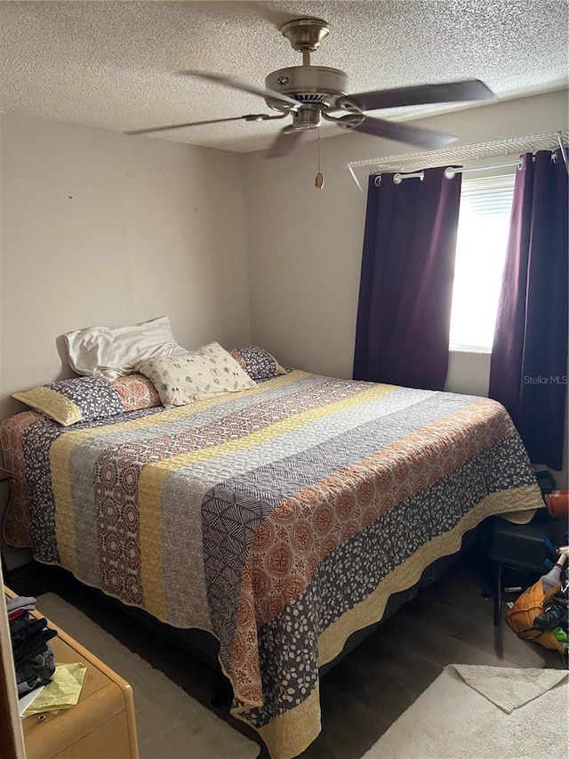 bedroom featuring ceiling fan, a textured ceiling, and wood finished floors