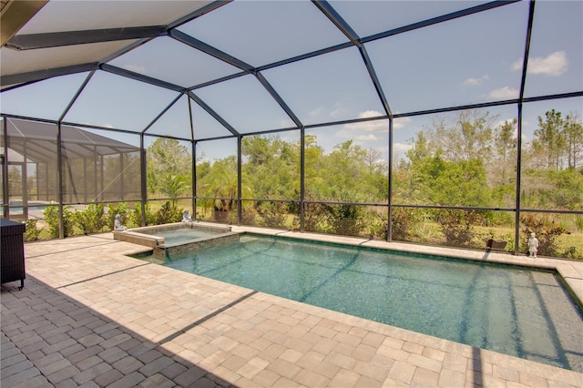 view of pool with a lanai, an in ground hot tub, and a patio area