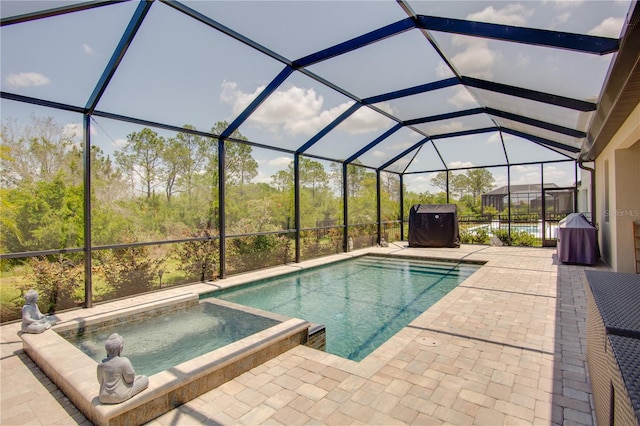 view of swimming pool featuring a patio, an in ground hot tub, and glass enclosure