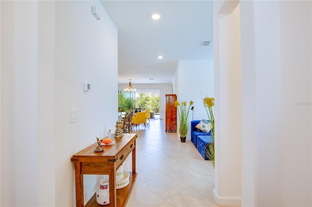 hall featuring an inviting chandelier and light tile patterned floors