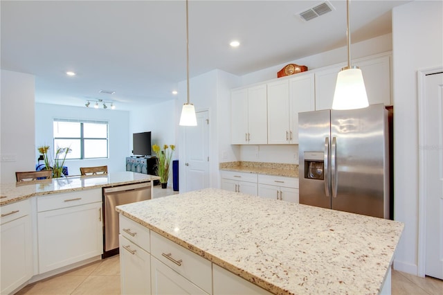 kitchen with light stone countertops, white cabinetry, appliances with stainless steel finishes, and hanging light fixtures