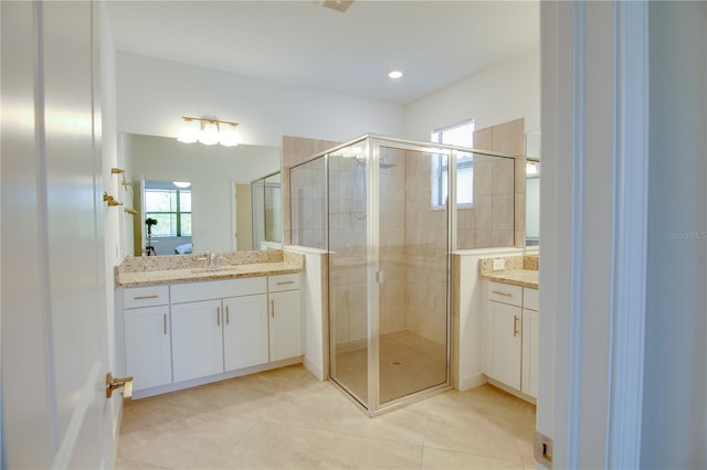 bathroom featuring vanity, tile patterned flooring, an enclosed shower, and a wealth of natural light