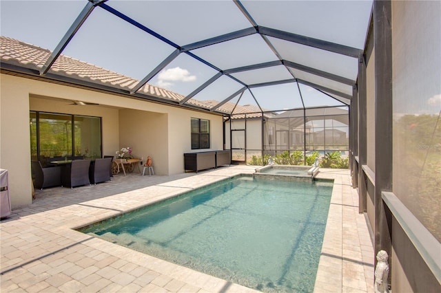 view of swimming pool featuring glass enclosure, ceiling fan, an in ground hot tub, and a patio area