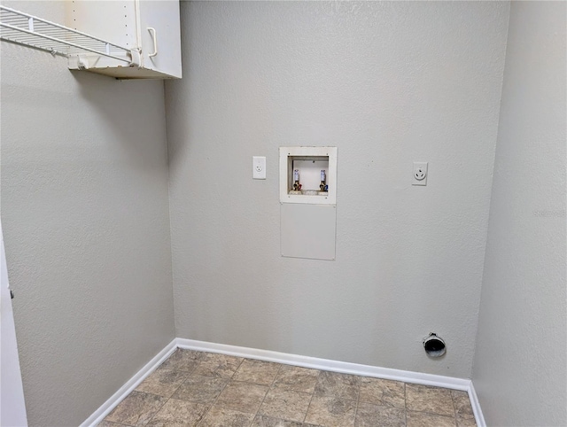clothes washing area featuring electric dryer hookup, cabinet space, washer hookup, baseboards, and stone finish floors