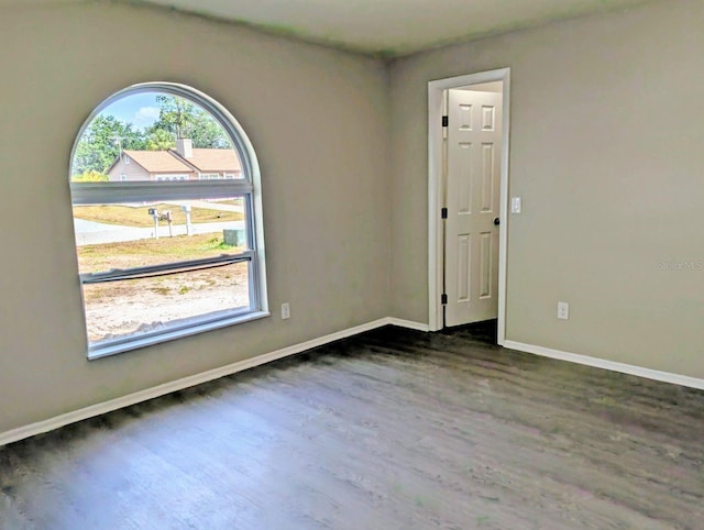 spare room featuring wood finished floors and baseboards