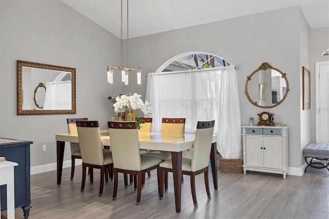 dining room featuring vaulted ceiling and light hardwood / wood-style floors