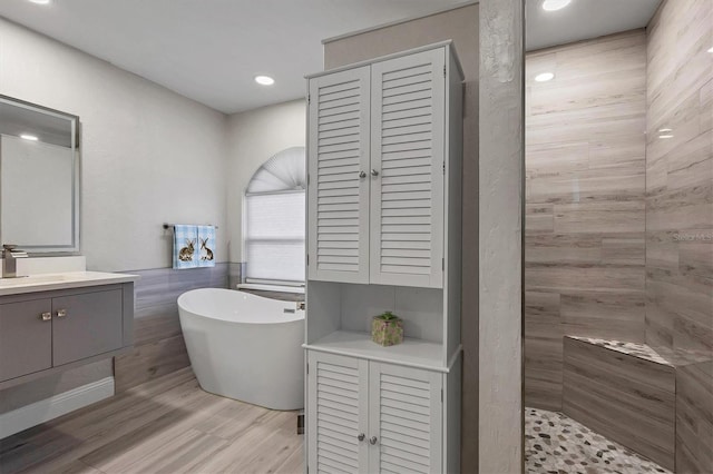 bathroom featuring vanity, independent shower and bath, wood-type flooring, and tile walls