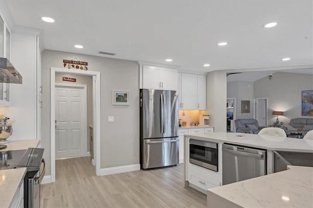 kitchen featuring stainless steel appliances, white cabinetry, light stone counters, and light hardwood / wood-style floors