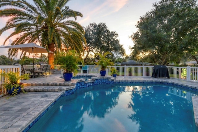 pool at dusk with a patio