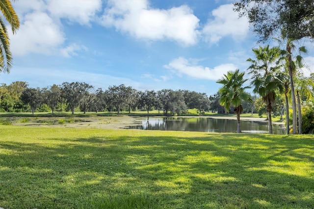 surrounding community with a water view and a yard