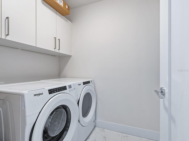 washroom with cabinets and washing machine and dryer