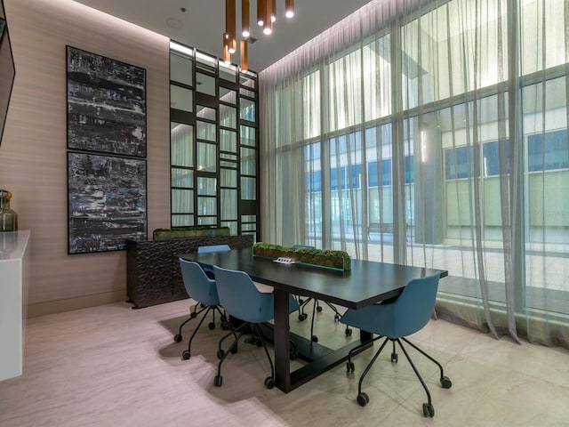 dining room featuring a towering ceiling and a wealth of natural light