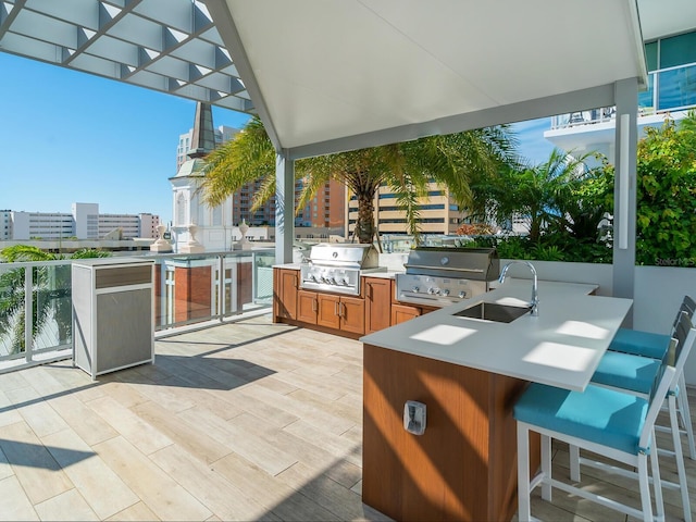 view of patio / terrace with an outdoor kitchen, a grill, and sink