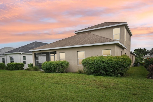 property exterior at dusk with a yard