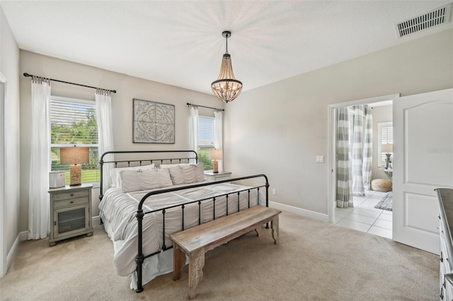 bedroom featuring light colored carpet and a chandelier