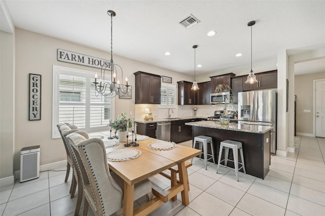 dining room with a notable chandelier, light tile patterned flooring, and sink