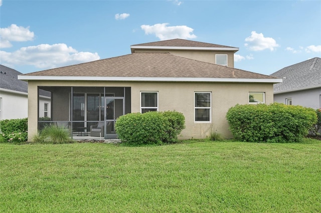 rear view of property featuring a yard and a sunroom