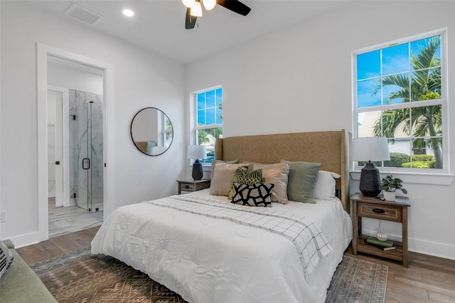 bedroom with hardwood / wood-style flooring, ceiling fan, and ensuite bath