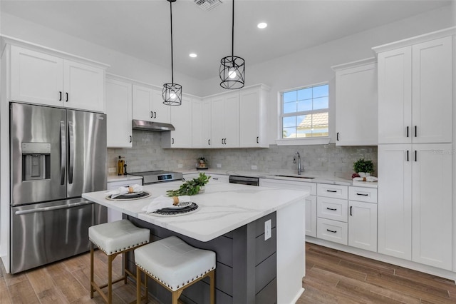 kitchen featuring a center island, sink, hanging light fixtures, white cabinets, and appliances with stainless steel finishes