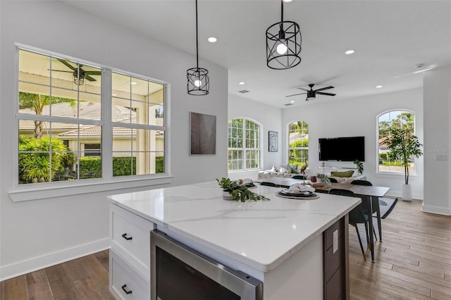 kitchen featuring white cabinets, dark hardwood / wood-style flooring, decorative light fixtures, and beverage cooler