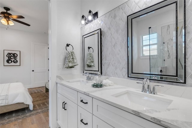 bathroom with hardwood / wood-style floors, ceiling fan, a shower with shower door, and vanity