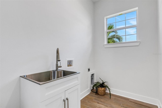 laundry room featuring hookup for an electric dryer, hookup for a washing machine, light wood-type flooring, and cabinets