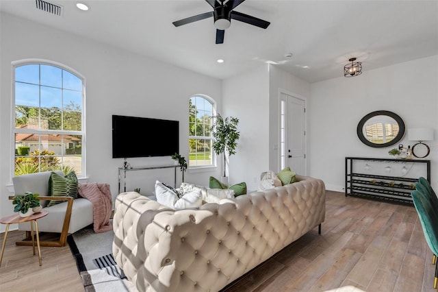 living room with light wood-type flooring and ceiling fan