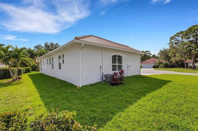 view of property exterior featuring central AC, a yard, and a garage