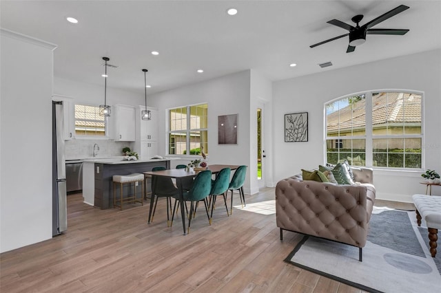 living room featuring light hardwood / wood-style flooring, ceiling fan, and sink