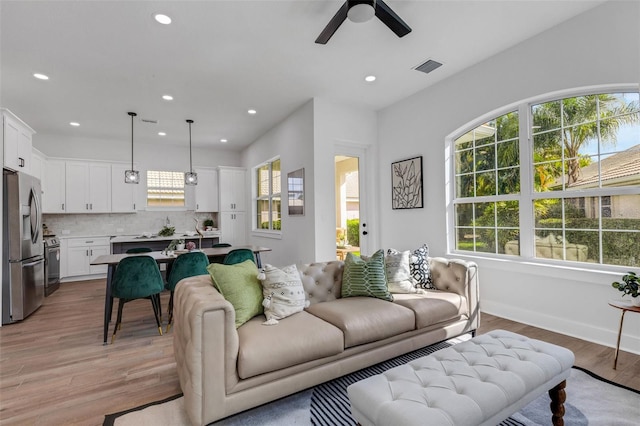 living room featuring light hardwood / wood-style floors and ceiling fan