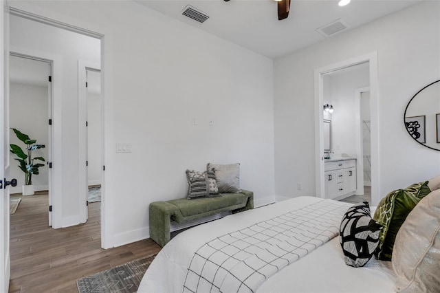 bedroom with ceiling fan, wood-type flooring, and ensuite bath