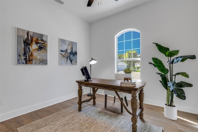 home office with light hardwood / wood-style flooring and ceiling fan