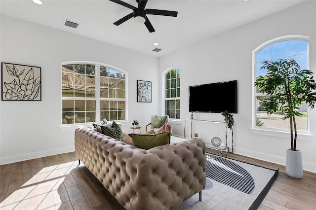 living room with plenty of natural light, ceiling fan, and light hardwood / wood-style flooring