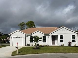 ranch-style home with a garage and a front lawn